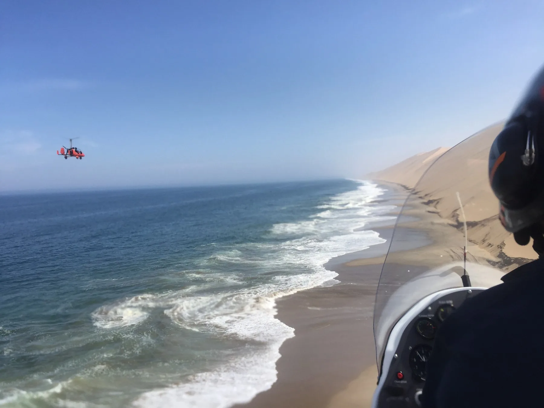 Atlantic surf and Namib dunes seen from a gyroplane cockpit